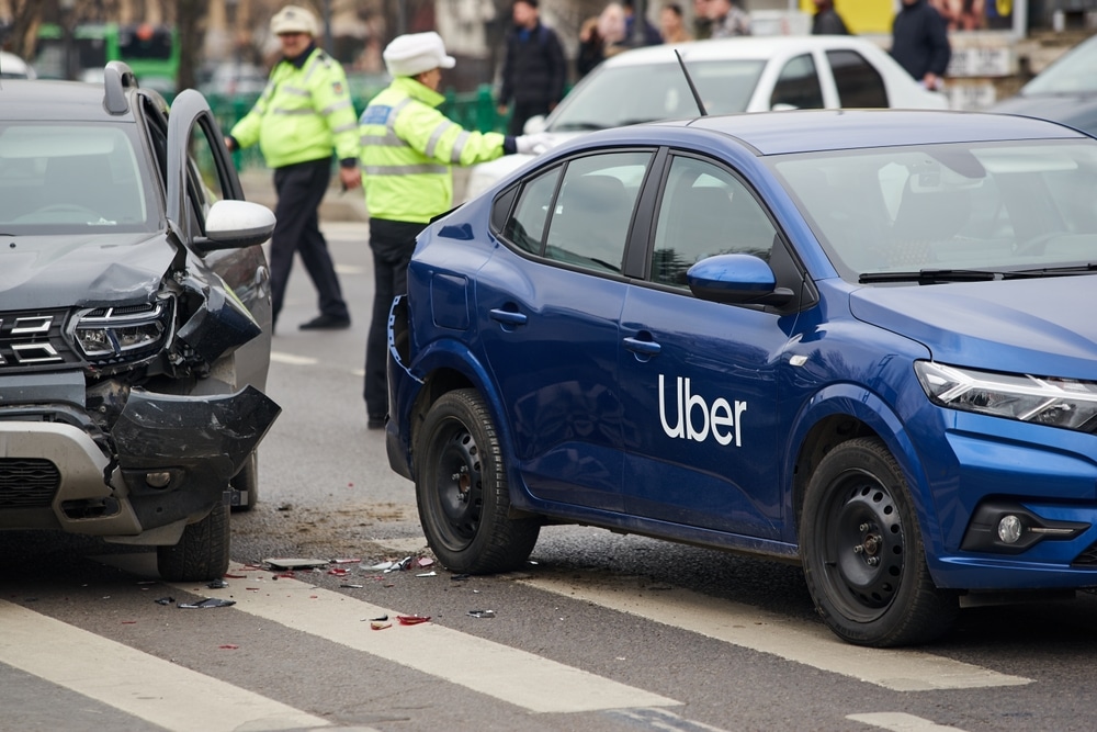 Damaged Uber vehicle after a collision in Dallas with police officers inspecting the scene