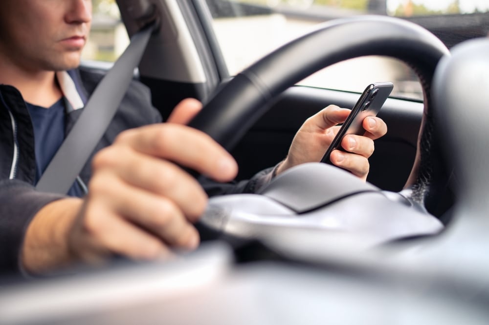 Rideshare driver distracted by phone while driving in Dallas traffic