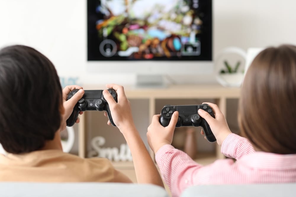 Two teenagers playing a console game together, symbolizing the growing concern over gaming addiction and its legal implications.