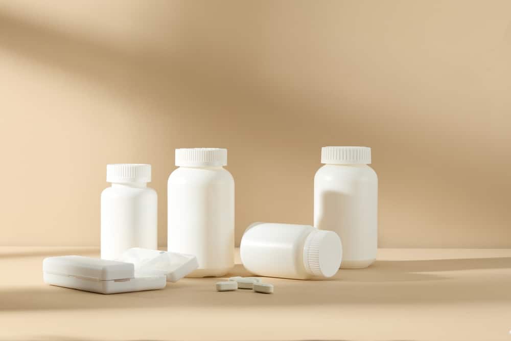 Assorted white medicine bottles on a neutral background symbolizing legal claims and product recalls for defective Oxbryta medication.