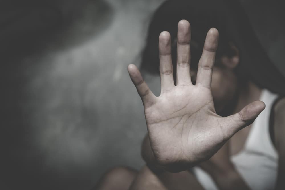 Person raising a hand in a stop gesture, symbolizing resistance, courage, and the fight to end sex trafficking.